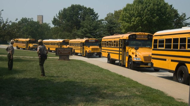 Rangers guiding school busses into the park.