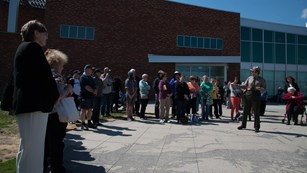 A ranger talking to a group of visitors behind the visitor center.
