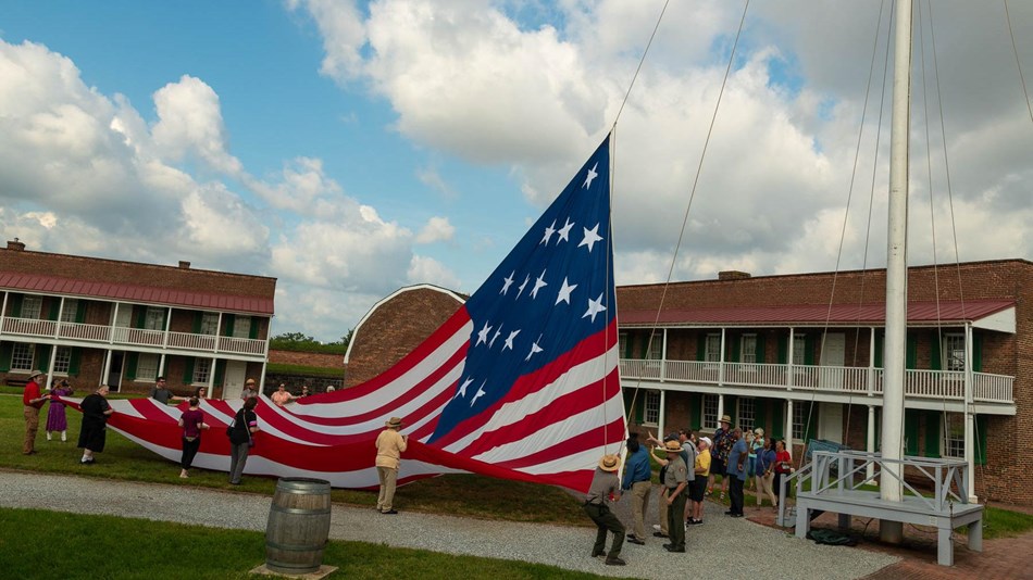 The garrison (30x42) flag being raised by a park ranger in the star fort.