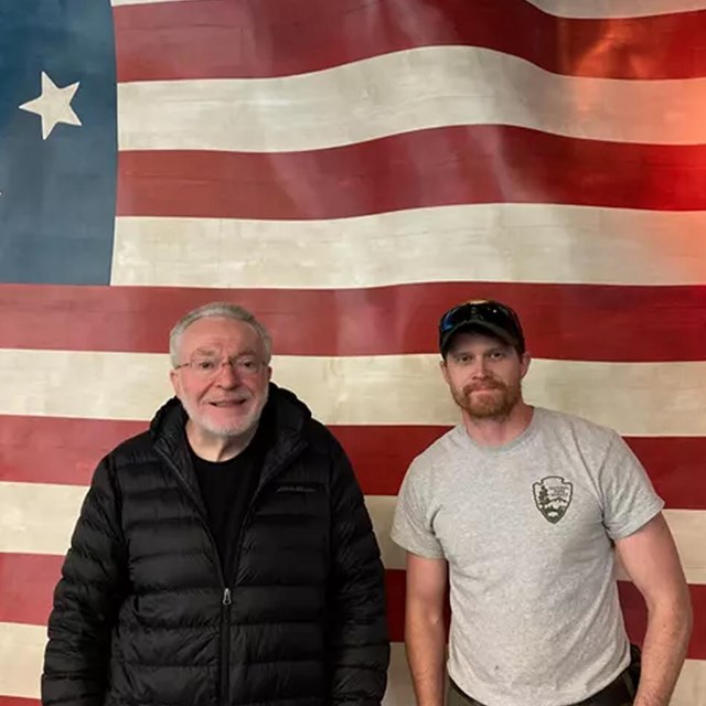 2 men in front of the historic USA flag