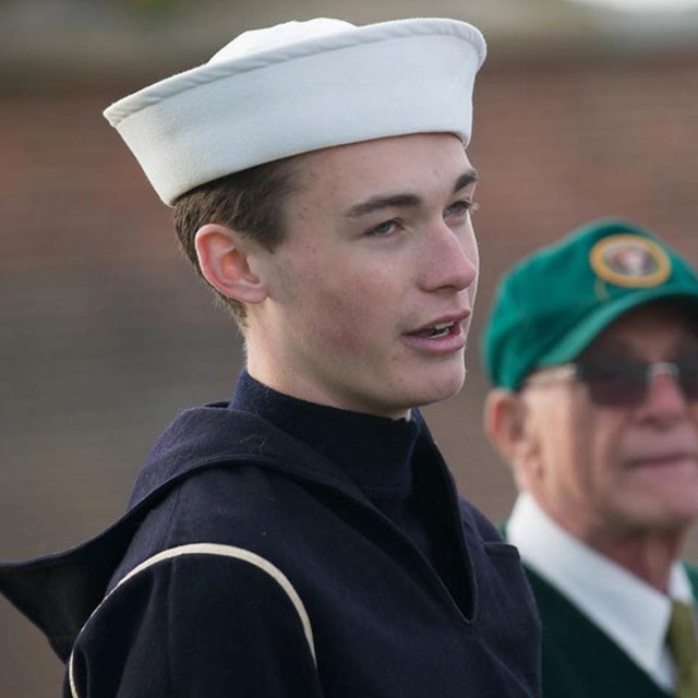 Living historian in U.S. Coast Guard uniform speaking with visitors