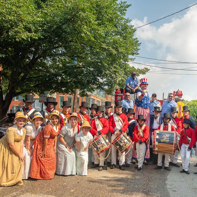 Living historians pose with parade participants in Federal Hill