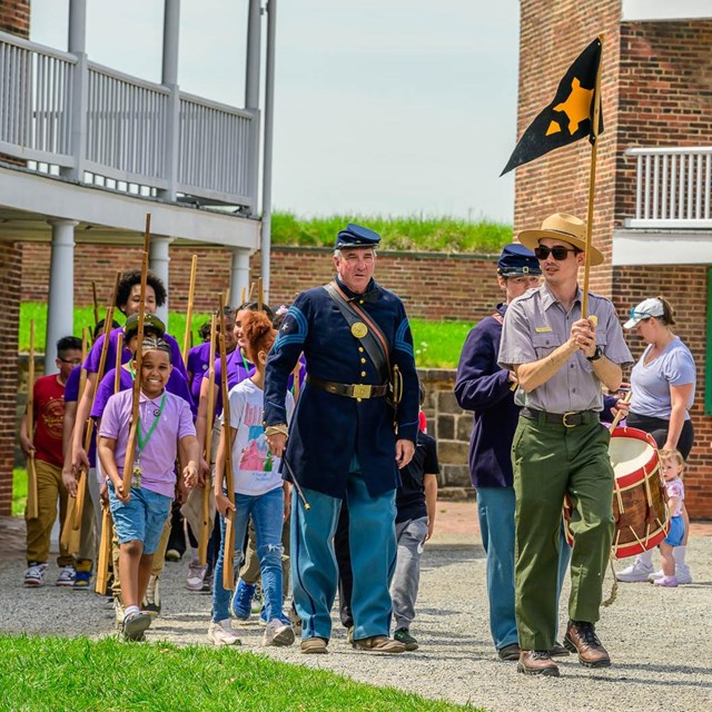 Rangers lead students on a march through the fort