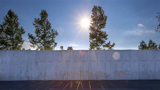 A white wall with passengers' names and the sun rising above.