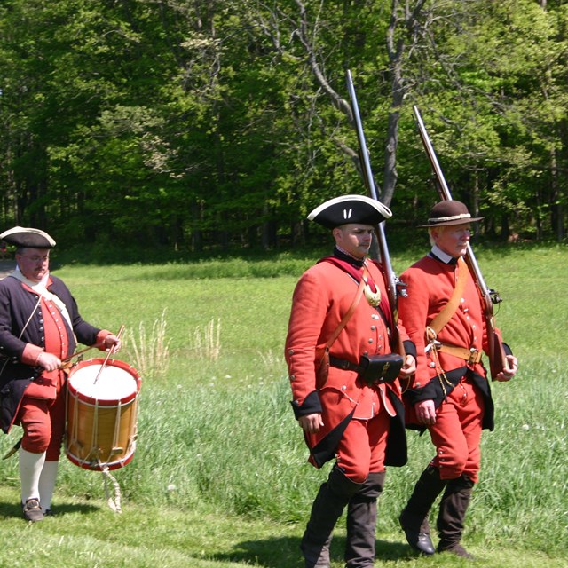 Soldiers marching with muskets on their shoulders