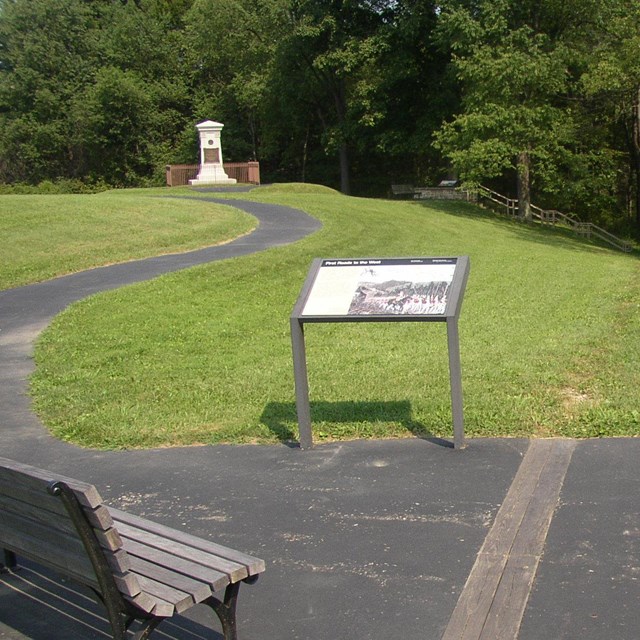 An interpretive sign and a white monument