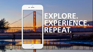 Image of cell phone with Golden Gate Bridge behind and text reading Explore. Experience. Repeat