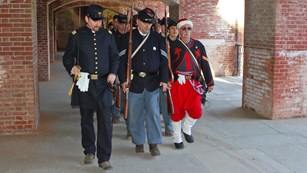 Civil War re-enacters walking through casemates at the fort