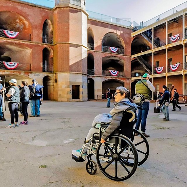 Person in wheelchair enjoying Fort Point's promenade.