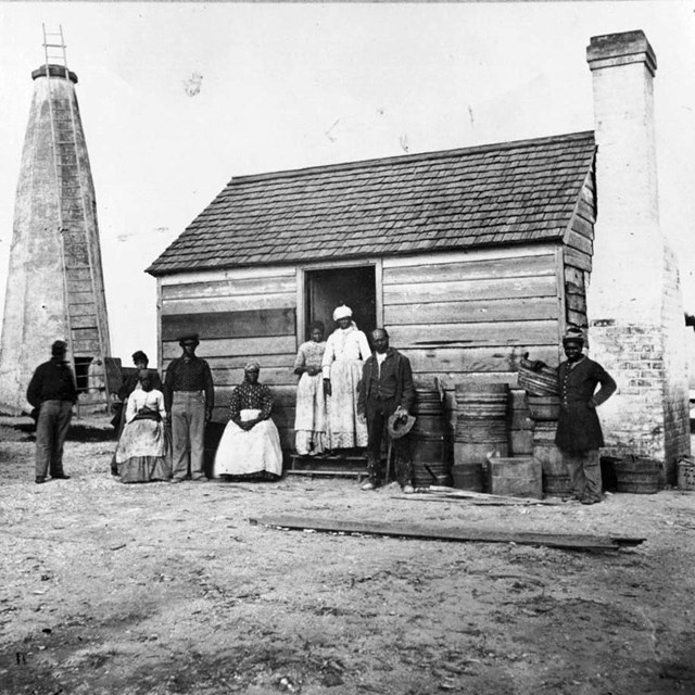 African American Family standing in front of wooden building