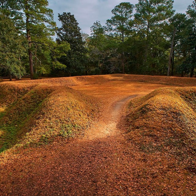 Reconstructed earthen fort covered in grass