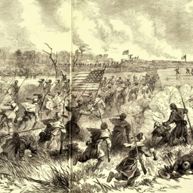 black and white photo of Civil War soldiers charging an earthen fort