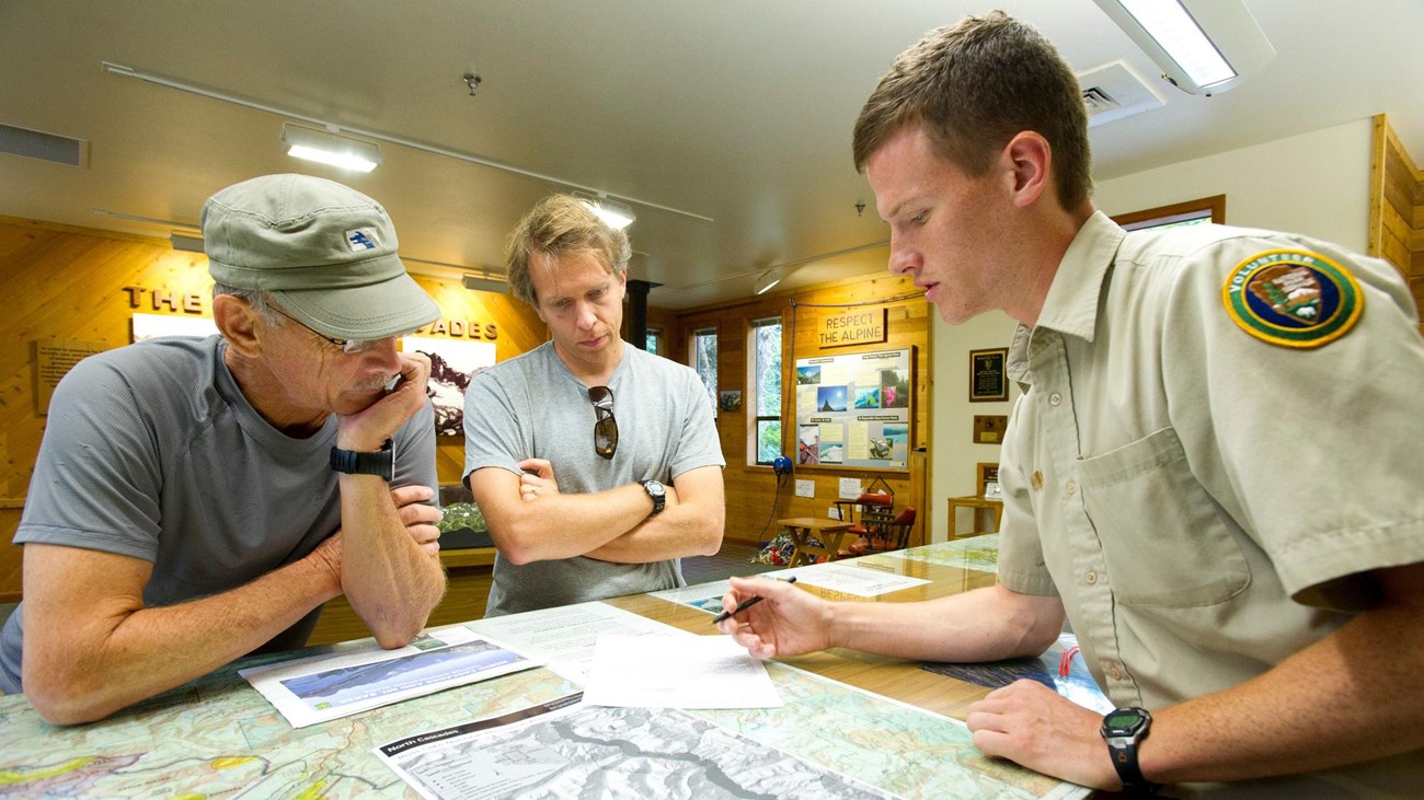 a volunteer shows map to two visitors