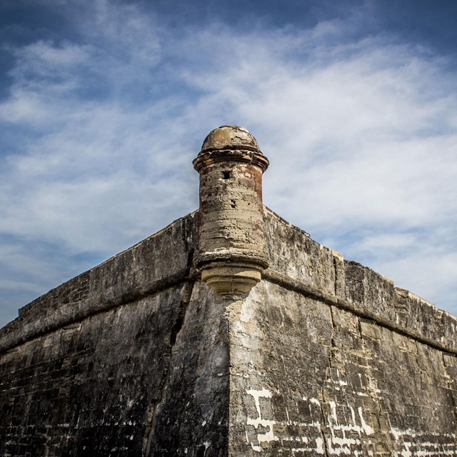 a blue sky behind a rampart of a masonry fort