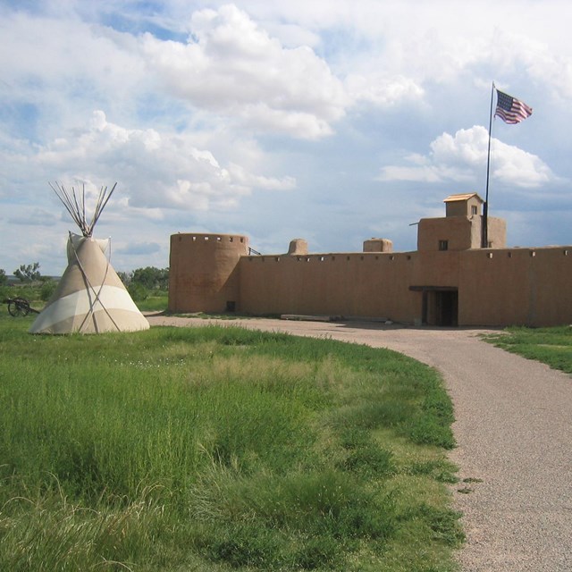 a tepee on the left and adobe fort on right