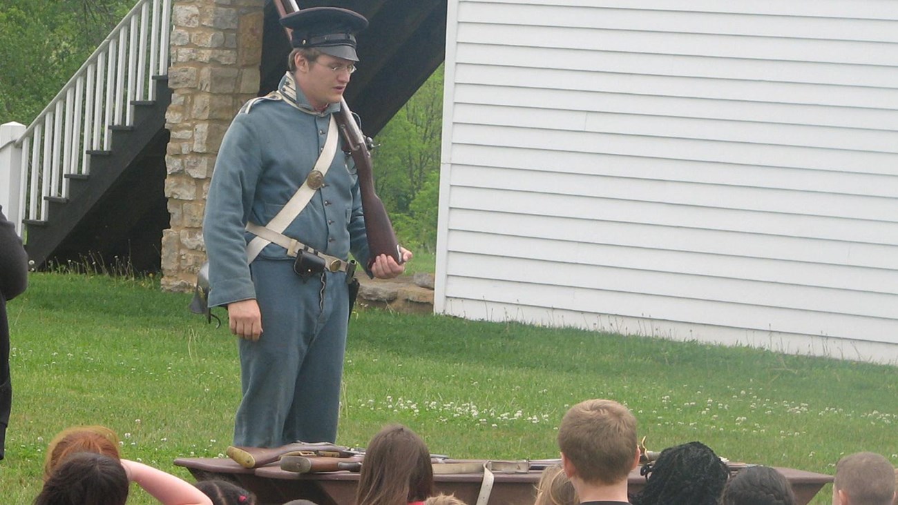 Student demonstrates gun to school children