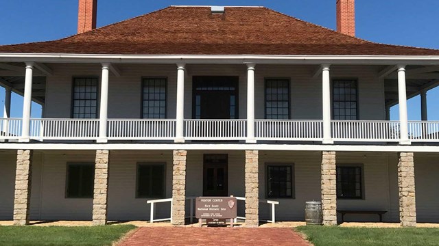 two story building with pillars and chimney on each side