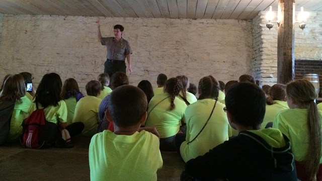 Park Ranger talking to students in the basement jail.