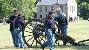 Union Civil War reenactors load a cannon.