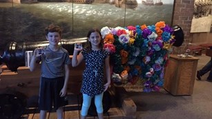 two children holding passes in front of cannon