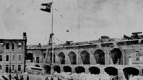Photograph of First National Flag of Confederacy flying over damaged Fort Sumter
