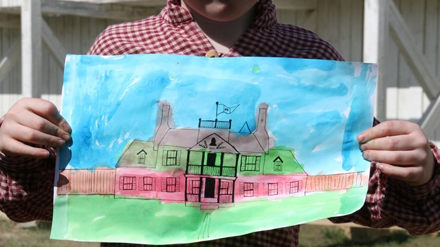 Child holding vibrant watercolor painting 