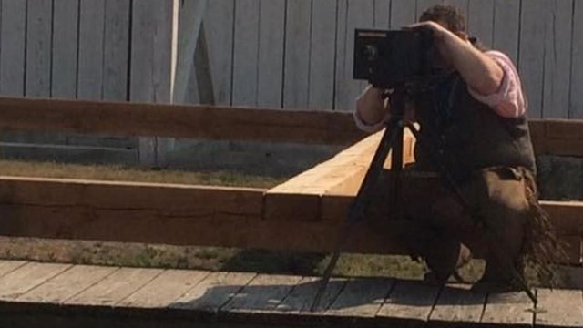 Man looking through the lens of a historic camera