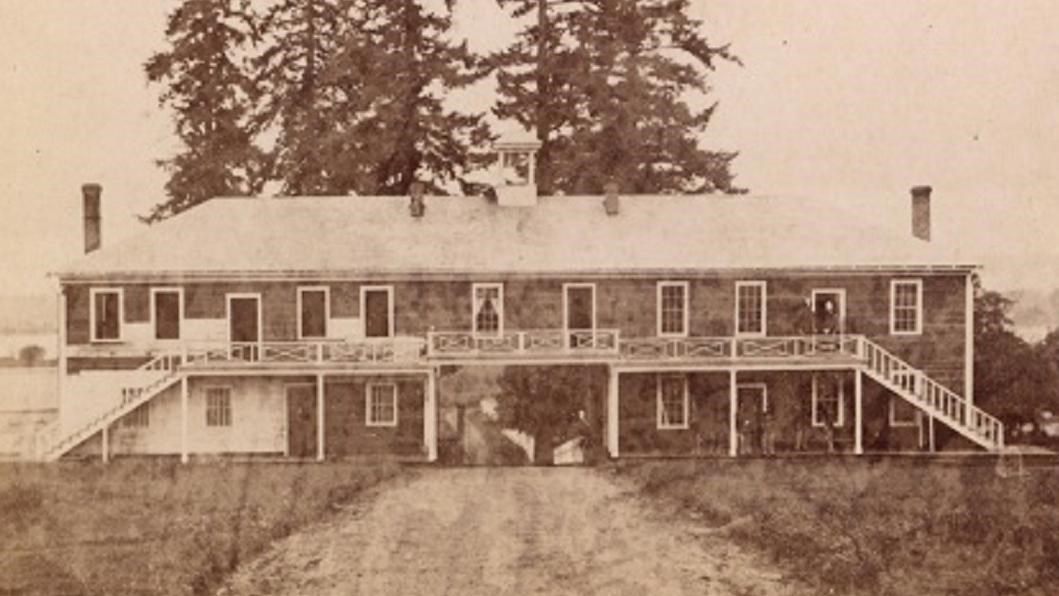 A black and white image of a two story building.