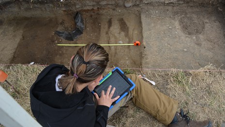 Image of a woman working at an archaeological site.