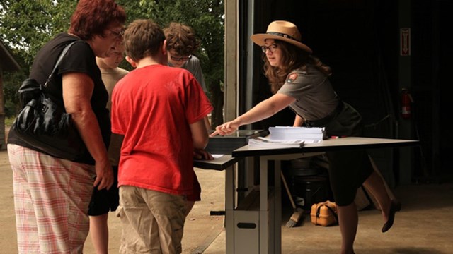 A photo of a curator talking with visitors.