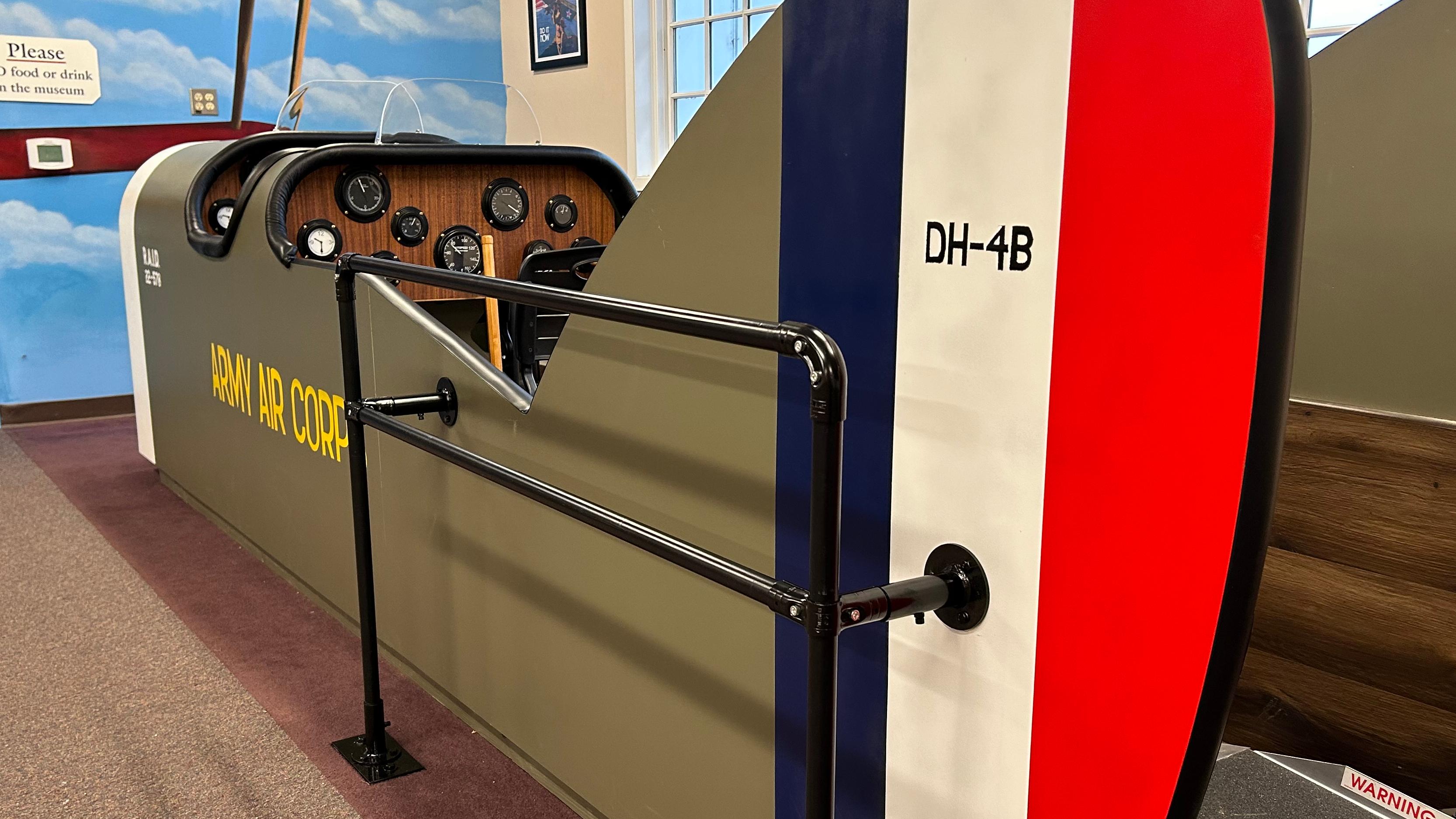 A large replica cockpit of a DH-4 Liberty plane in the Pearson Air Museum lobby.