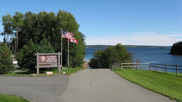  L'entrée du parc, avec le signe et le drapeau sur la gauche et de l'eau en arrière-plan.