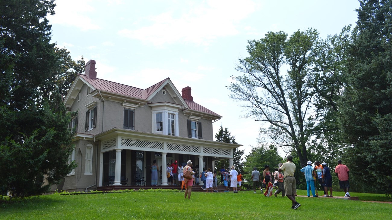 A group of visitors in front of a historic house