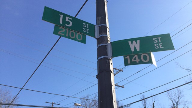 Two street signs on a post reading "15 St SE" and "W St SE"