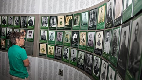 Visitor examines wall of faces exhibit at the Chancellorsville Visitor Center