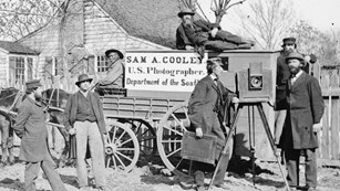 Historical photography covered wagon pulled by horses.