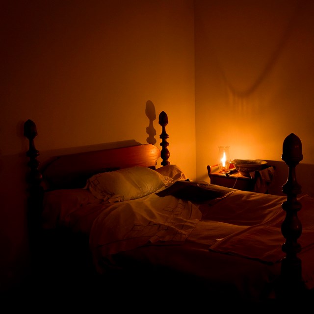 Four poster bed in which Stonewall Jackson died, illuminated by candlelight 