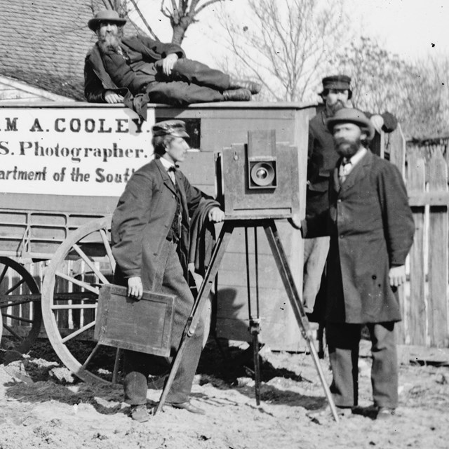 Historical photography covered wagon pulled by horses.