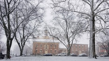 Snow falls on The Dover Green.
