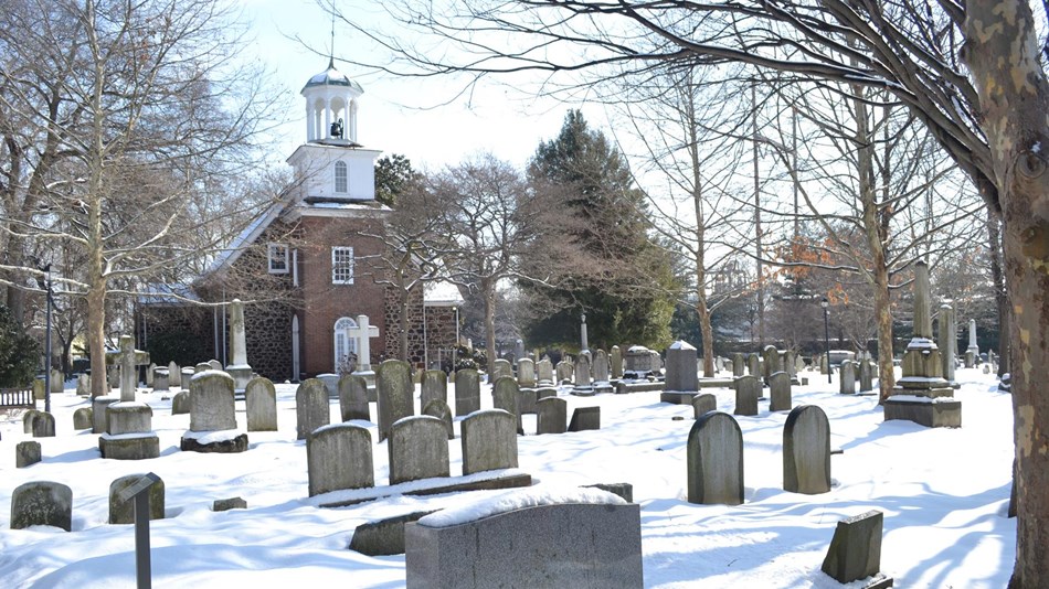 The burial ground at Old Swedes Church covered in snow on a winter morning.