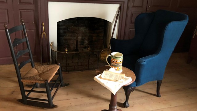 Two chairs by the fireplace inside Poplar Hall. 