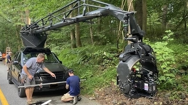 Workers set up a vehicle for filming on the road. 