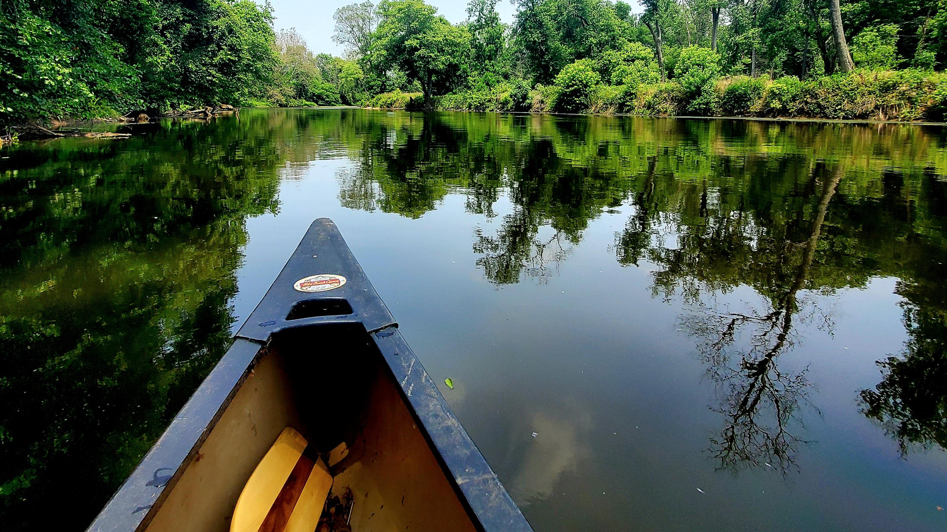 A canoe travels on smooth water along the Brandywine Creek