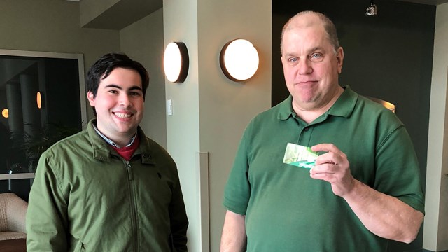 The park's volunteer coordinator hands a volunteer their free Volunteer-In-Parks Pass. 