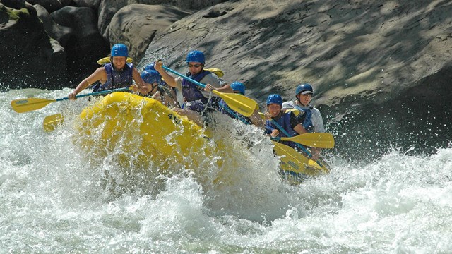 whitewater rafters crash through a rapid