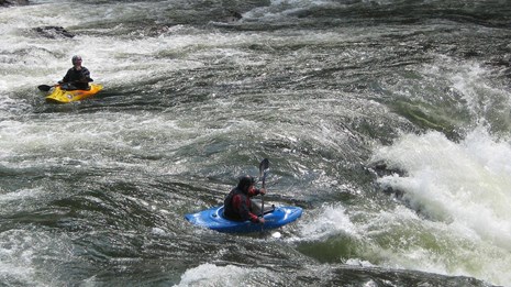 two kayakers approach rapids