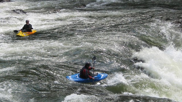 two kayakers approach rapids 