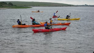 Kayakers in red and orange kayaks