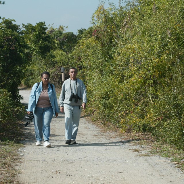 Two people walking on the West Pond loop at Jamaica Bay Wildlife Refuge