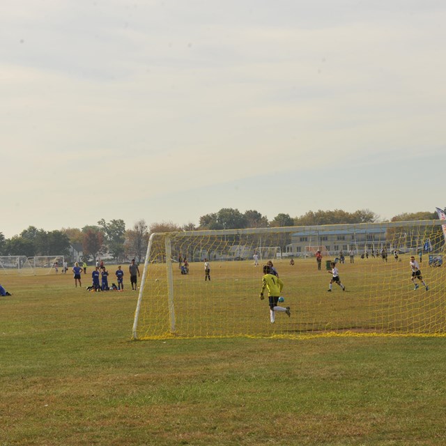 Kids playing soccer on a historic airfield in Gateway National Recreation Area.